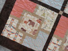 a close up of a patchwork quilt with animals on the front and back side