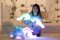 a woman sitting on the floor with three stuffed animals