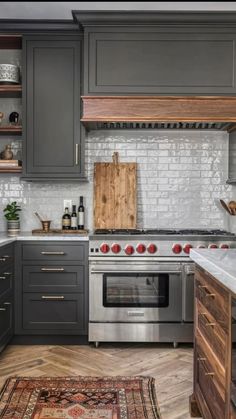 a kitchen with gray cabinets and white marble counter tops