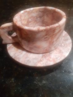 a marble cup and saucer on a black table