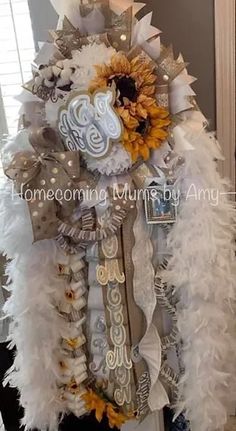 a sunflower and white feather wreath on top of a door