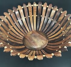 a large wooden bowl with many different designs on it's sides and the center piece is made out of wood