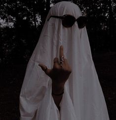 a person in a ghost costume holding their hand up