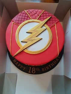 a birthday cake with the flash symbol on it in a box for someone's 18th birthday