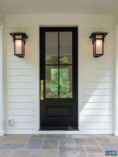 a black front door with two lights on it