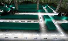 an empty room with green benches and arrows on the floor