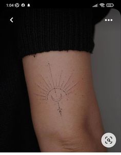 a woman's arm with a small sun and moon tattoo on the left side