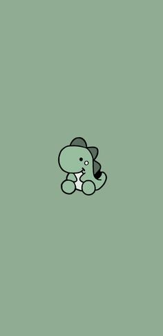 a small green teddy bear sitting on top of a green floor next to a wall