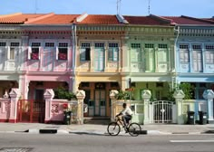 a person riding a bike down the street in front of colorful buildings