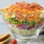 a glass bowl filled with lots of food on top of a table