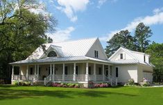 a large white house sitting on top of a lush green field