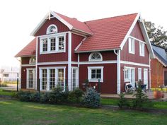 an image of a red house with white trim on the front and side windows that are open