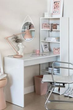 a white desk and chair in a small room with a mirror on the wall above it