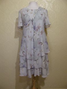 This is a very pretty 2 piece sleeveless long layered dress with matching long sheer chiffon jacket by r&m richards. still in brand new condition. it is a size 8. please go by the measurements below for proper fit. very elegant pretty women look. perfect for a garden party or summer wedding. the dress has a modest scoop neckline with a small keyhole button back. the dress is made of a pastel light sage green floral print crepe chiffon. the flowers are very light pastels of pinks and periwink Fitted Summer Dress With Overlay, Spring Short Sleeve Dress With Overlay, Spring Dress With Short Sleeves And Overlay, Spring Dresses With Overlay And Short Sleeves, Flowy Spring Dress With Overlay, Spring Knee-length Dress For Mother Of The Bride, Knee-length Spring Dress For Mother Of The Bride, Summer Flowy Dress For Mother Of The Bride, Spring Formal Dress With Overlay