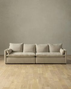 a beige couch sitting on top of a wooden floor