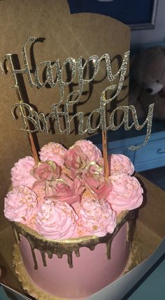 a birthday cake with pink frosting and sprinkles on top, sitting in a box