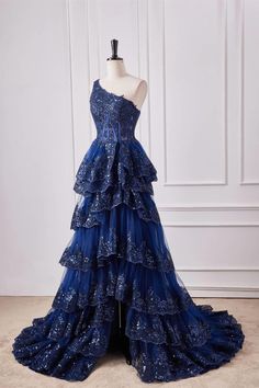 Constructed with tulle fabric in a striking navy blue hue, this A-line prom dress boasts an embellished bodice with delicate appliques, a daring side slit, and a cascading ruffled skirt. The one-shoulder neckline adds a touch of elegance while the zip-up back ensures a secure fit. Featuring a full-length hemline, this dress is the perfect choice for a formal occasion. Item #NP1084 Material: Tulle Color: Navy blue Silhouette: A-line Embellishment: Appliques, side slit, ruffles skirt Neck: One sho Ruffle Prom Dress, Sheer Corset, Prom Dresses Long Lace, Lace Formal Dress, Corset Bodice, Custom Size Dresses, Fantasy Dress, Prom Dresses Lace, Long Prom Dress