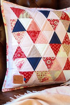 a red, white and blue quilted pillow on a couch