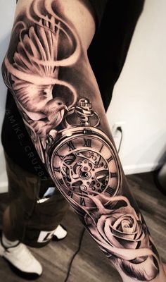 a man's arm with a clock and roses on it