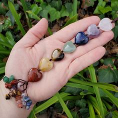 a person's hand holding five different colored rocks and stones in their left palm