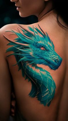 a woman's back with a blue dragon tattoo on her upper arm and shoulder