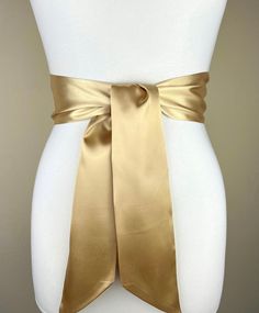 "Pale Gold Satin Sash, Light Gold Sash Belt  Wide Gold Wedding Dress Sash  Gold Bridal Sash Belt  Pale Gold Bridesmaid Sash  Satin Swank  This Satin Swank® reversible waist sash is the perfect finishing touch for your bridesmaid, wedding, or special occasion dress, or just the right piece to add instant polish to your dress or top. Depending on your waist size and the length you choose (60, 75, and 90 inch lengths available), you can wrap the sash around your waist once or twice. You decide whether to tie the sash in a bow or a simple knot with long-hanging tails. Tie in front, in back, or on the side. Luxury charmeuse satin fabric in luminous pale gold on both sides means there is no wrong side of the sash peeking through, resulting in the perfect finishing touch for your special occasion Luxury Elegant Sashes, Wedding Sash With Tie Back, Satin Bridal Belt For Party, Satin Sash With Bow For Bridesmaids, Satin Bridal Belt For Bridesmaids, Elegant Satin Sash With Tie Back, Bridesmaid Sash With Satin Bow, Bridesmaid Satin Sash With Satin Bow, Bridesmaid Satin Sash With Bow