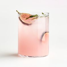 a glass filled with a pink drink and garnished with rosemary