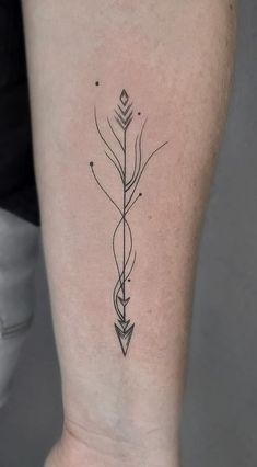 an arrow tattoo on the back of a woman's left leg, which is black and white