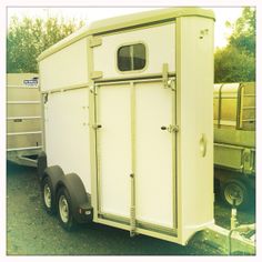 a white trailer parked next to another trailer