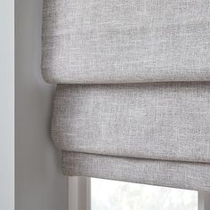 the roman blind is made from light gray linen