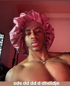 a shirtless man wearing a pink turban