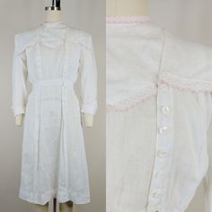 "Late 1910s(circa 1918) dress ~White linen/cotton ~Pink swiss dot scalloped trim ~Side front shell buttons Brand: none Hand washed and ready to wear. Condition: Very good. Some small holes and spots. Slight yellowing to edge of trim on neck band. Neck appears to have been let out at some point-one side of neck is unattached and will need to be pinned or a snap or hook added Size: Fits like a modern XS *please consult measurements to ensure fit Measurements Bust: 35\"(36\" snug) Waist: 25\" Hip: Cotton Victorian Dress With Buttons For Daywear, Fitted Cotton Victorian Dress For Daywear, Victorian Daywear Dresses With Buttons, Feminine Spring Victorian Daywear Dress, Fitted Cotton Vintage Dress For Daywear, Fitted Vintage White Dress For Daywear, Victorian Cotton Daywear Dress, Feminine Fitted Victorian Daywear Dress, Feminine Fitted Victorian Dress For Daywear