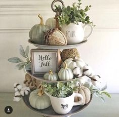 three tiered tray with white pumpkins, greenery and other fall decorations on it