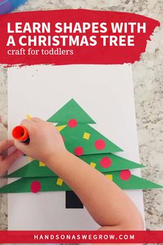 someone is making a christmas tree out of construction paper with crayons on it