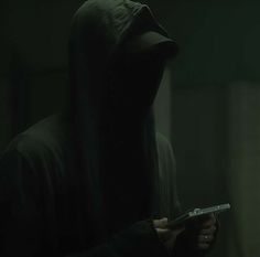 a person in a hooded jacket holding a remote control