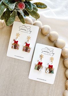 two christmas themed earrings sitting on top of a table