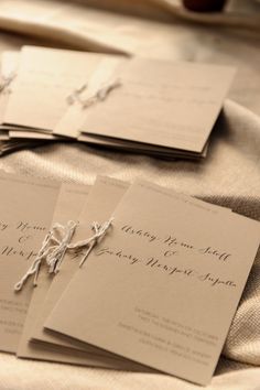 the wedding stationery is laid out on top of each other, ready for guests to arrive