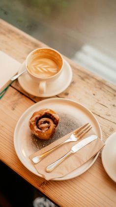 there is a plate with a pastry on it next to a cup of coffee