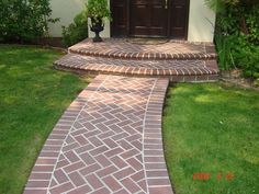 a brick walkway leading to a door in a house