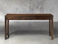 a wooden table with two drawers sitting on it's side, in front of a concrete wall