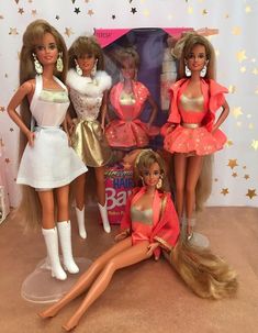 four barbie dolls are posed together in front of a birthday cake with stars on it