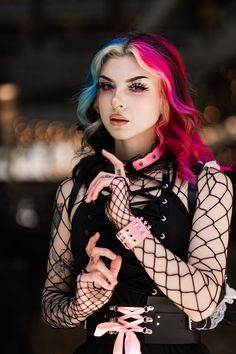 a woman with pink and blue hair posing for the camera