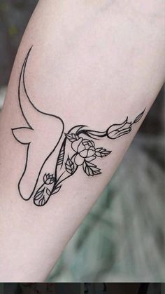 a tattoo on the arm of a woman with flowers and an animal's head