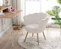 a white chair sitting on top of a wooden floor next to a desk with a mirror