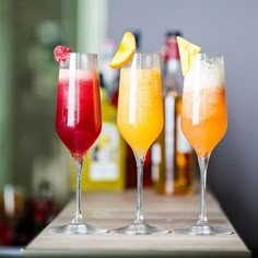 three glasses filled with different types of drinks