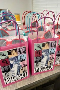 pink shopping bags with photos of taylor swift and taylor's sisters on them sitting on a table