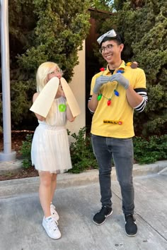 a man and woman dressed up in costumes standing next to each other on the sidewalk