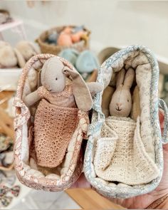 two stuffed animals are in small baskets on a table