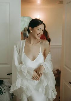 a woman in a white dress is smiling