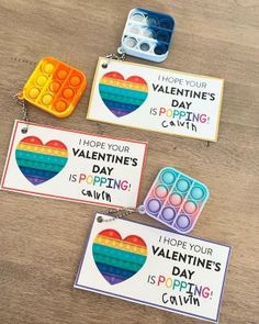 three valentine's day cards with magnets attached to them on a wooden table